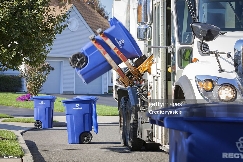 Recycling Truck Lifting Up Container Along Neighborhood Curb