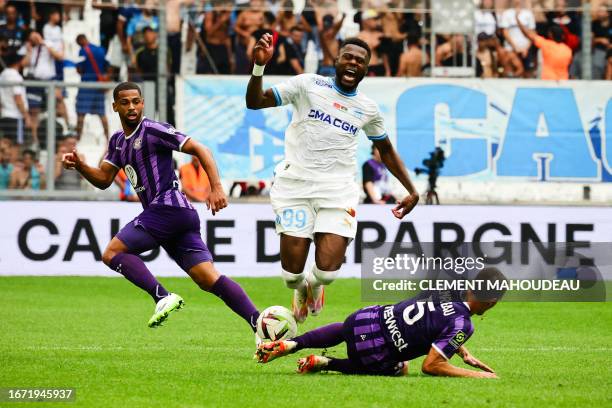 Marseille's Congolese defender Chancel Mbemba is tackled by Toulouse's Australian midfielder Denis Genreau during the French L1 football match...