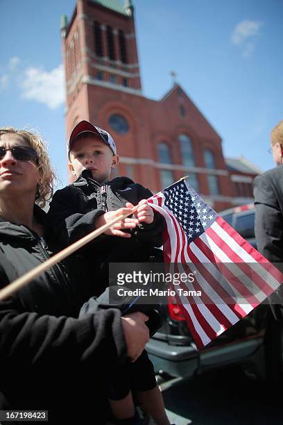 Shane Higgins poses holding an American flag with his mother Jaida outside the funeral for 29-year-old Krystle Campbell, who was one of three people...