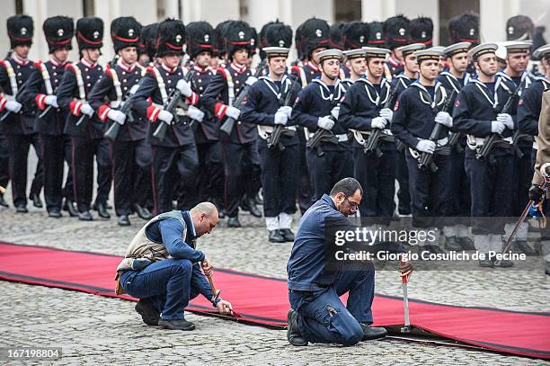 Workers fix a red carpet in front of the guard of honor as they wait the arrival of the newly elected President Giorgio Napolitano at Palazzo del...