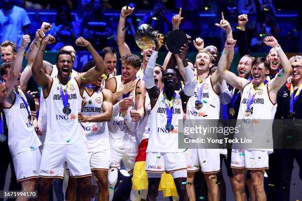 Dennis Schroder of Germany lifts the Naismith Trophy as he celebrates with teammates after the FIBA Basketball World Cup Final victory over Serbia at...