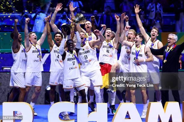 Dennis Schroder of Germany lifts the Naismith Trophy as he celebrates with teammates after the FIBA Basketball World Cup Final victory over Serbia at...