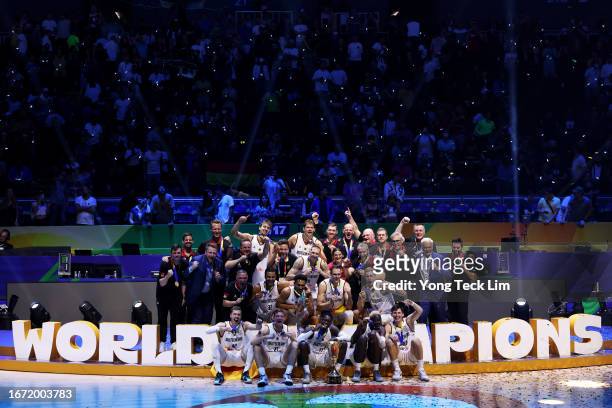 Germany players, coaches and team officials pose for photos with the Naismith Trophy after the FIBA Basketball World Cup Final victory over Serbia at...