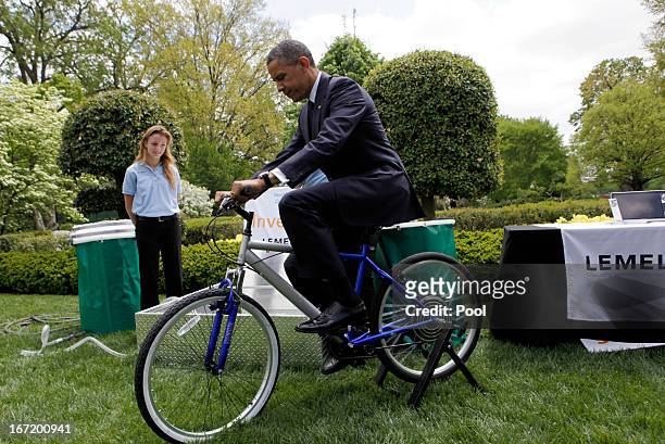 President Barack Obama tries the bicycle-powered emergency water-sanitation station, created by high schoolers Payton Karr and Kiona Elliot from...