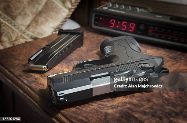 semi-automatic pistol on bedside nighstand - pistolenschießen stock-fotos und bilder