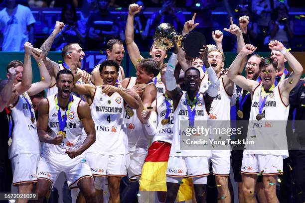 Dennis Schroder of Germany lifts the Naismith Trophy as he celebrates with teammates after the FIBA Basketball World Cup Final victory over Serbia at...