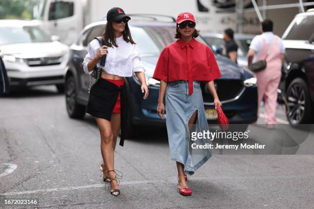 Guests are seen outside Tibi show wearing red NYC cap, red cropped Patrizia Pepe shirt with red necktie, blue denim asymmetric skirt with open front,...