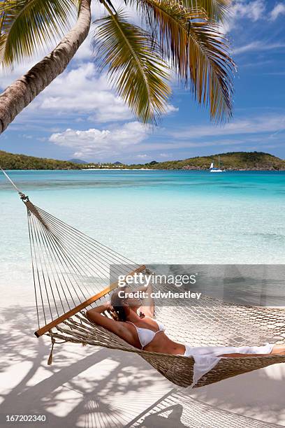 woman getting some sun in hammock at the caribbean beach - caribbean sea stock pictures, royalty-free photos & images