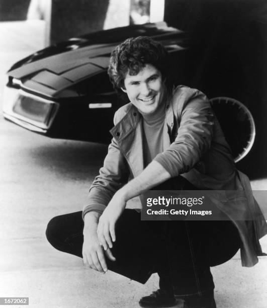 American actor and singer David Hasselhoff poses next to the computerized car, K.I.T.T., in a promotional portrait for the television series, 'Knight...