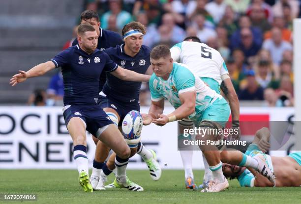 Jasper Wiese of South Africa offloads the ball under pressure from Finn Russell of Scotland during the Rugby World Cup France 2023 match between...