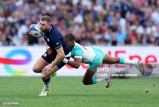 Finn Russell of Scotland is tackled by Manie Libbok of South Africa during the Rugby World Cup France 2023 match between South Africa and Scotland at...