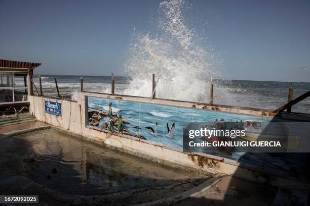 Waves spray water on structures on the seaside of Kalk Bay in Cape Town on September 17, 2023 following the spring high tide in the Western Cape...