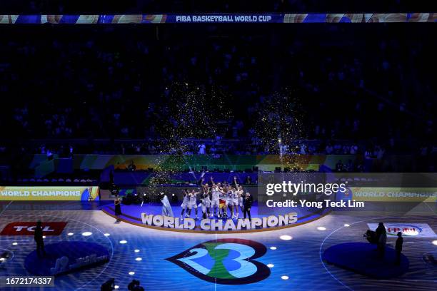 Dennis Schroder of Germany lifts the Naismith Trophy as he celebrates with teammates after the FIBA Basketball World Cup Final victory over Serbia at...