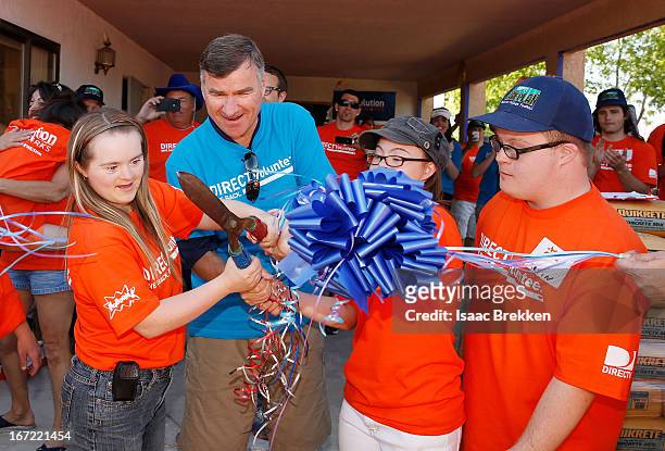 DirecTV CEO Mike White cuts a ribbon following a DirecTV playground build for the Down Syndrome Organization of Southern Nevada on April 22, 2013 in...
