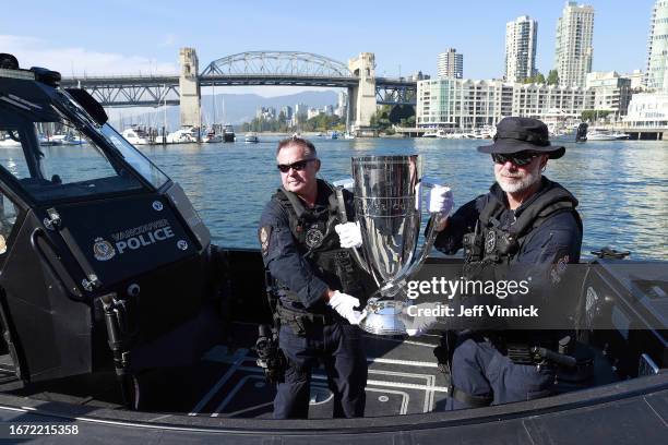 Two Vancouver Police officers hold the Laver Cup Trophy on a police boat in False Creek on September 16, 2023 in Vancouver, British Columbia, Canada.