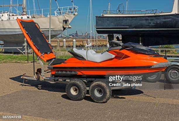 orange jet ski stands outside on a trailer - outboard motor stock pictures, royalty-free photos & images