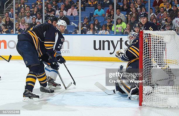 Aaron Gagnon of the Winnipeg Jets scores a second period goal against Jhonas Enroth of the Buffalo Sabres while defended by Mike Weber of the Sabres...