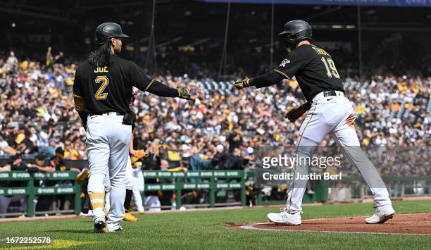 Jared Triolo of the Pittsburgh Pirates is met by Connor Joe after coming around to score on a RBI single by Liover Peguero in the third inning during...