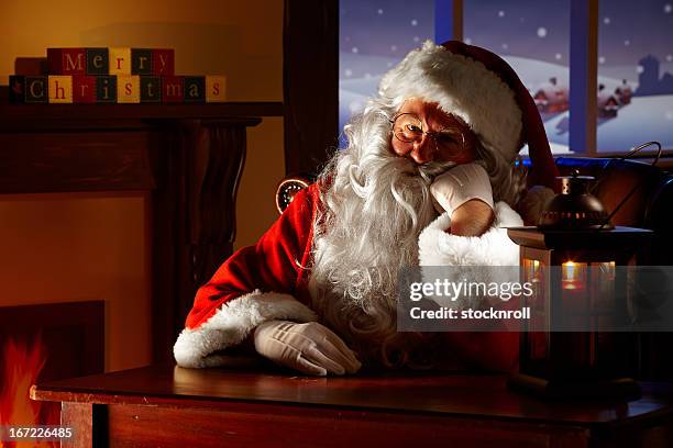 nahaufnahme des gelangweilt santa sitzen in seinem grotto - santa close up stock-fotos und bilder