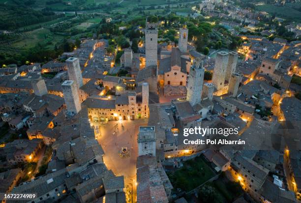 san gimignano town at night with its skyline of medieval towers, including the stone torre grossa. unesco world heritage site. province of siena, tuscany, italy - siena province - fotografias e filmes do acervo