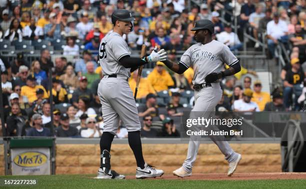 Estevan Florial of the New York Yankees is met by Aaron Judge after coming around to score on a RBI double by DJ LeMahieu in the sixth inning during...