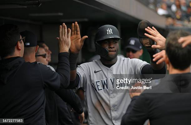 Estevan Florial of the New York Yankees celebrates with teammates in the dugout after coming around to score on a RBI double by DJ LeMahieu in the...