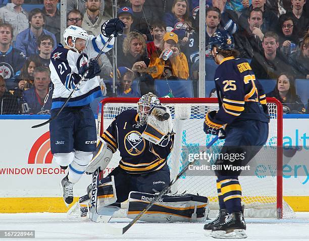 Jhonas Enroth of the Buffalo Sabres makes a glove save alongside teammate Mikhail Grigorenko and Aaron Gagnon of the Winnipeg Jets on April 22, 2013...