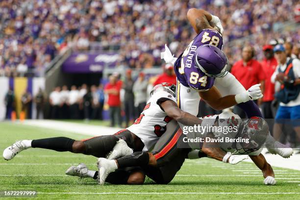 Josh Oliver of the Minnesota Vikings is tackled by Antoine Winfield Jr. #31 and Jamel Dean of the Tampa Bay Buccaneers in the second quarter of a...