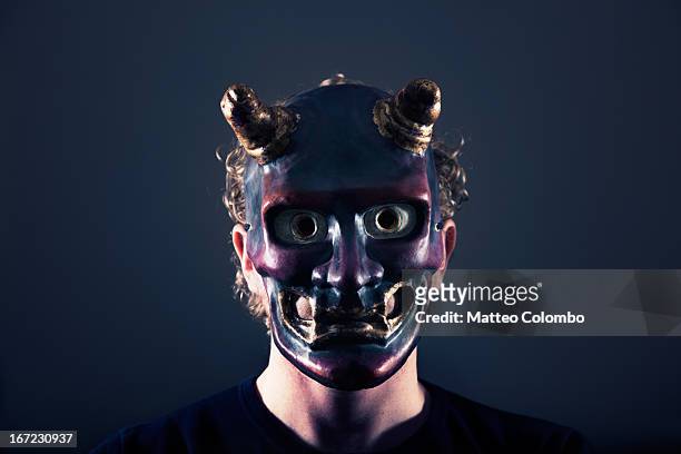man wearing devil's mask - disfraz de diablo fotografías e imágenes de stock