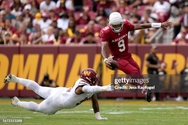 Joshua Dobbs of the Arizona Cardinals leaps out of an attempted tackle by Jonathan Allen of the Washington Commanders during the second quarter at...