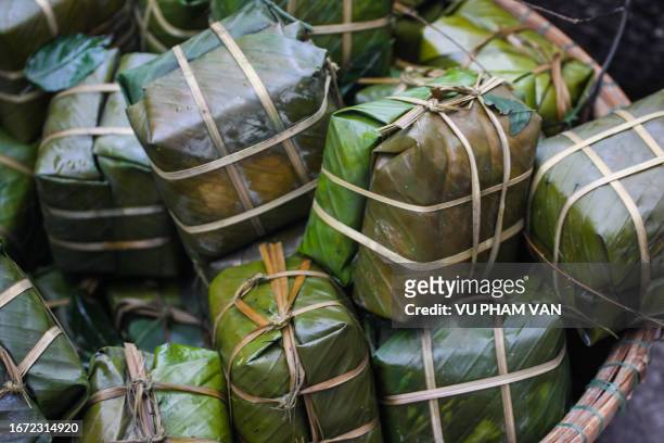 cooked sticky rice cakes stuffed with mungbeans and pork wrapped in banana leaves - vietnam stock pictures, royalty-free photos & images