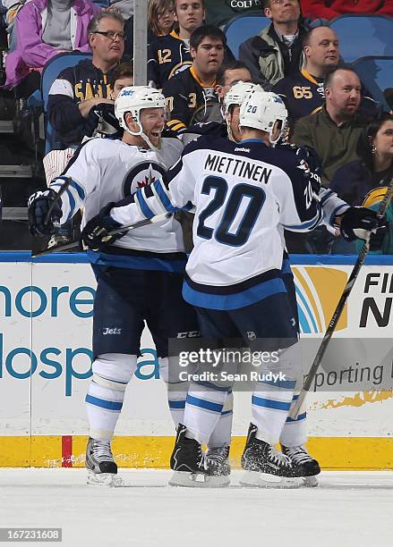 Aaron Gagnon of the Winnipeg Jets celebrates his second period goal against the Buffalo Sabres with teammates Antti Miettinen and Derek Meech at...