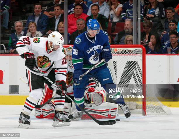 Jannik Hansen of the Vancouver Canucks redirects the puck for a goal while being checked by Johnny Oduya of the Chicago Blackhawks during their NHL...