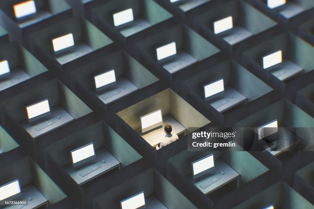 Surreal image of office cubicles with man working late