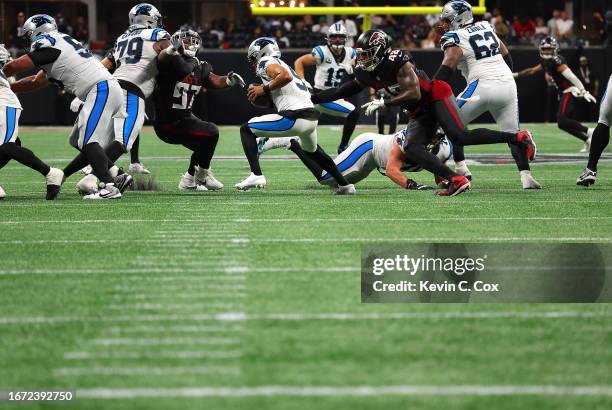 Bryce Young of the Carolina Panthers is pressured by Grady Jarrett of the Atlanta Falcons and Bud Dupree of the Atlanta Falcons during the fourth...