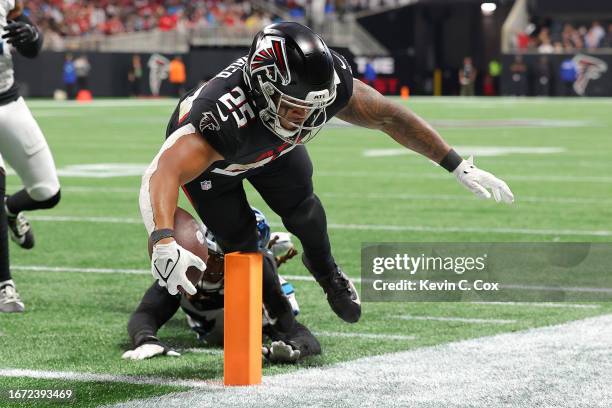 Tyler Allgeier of the Atlanta Falcons scores a touchdown past Shaq Thompson of the Carolina Panthers during the fourth quarter at Mercedes-Benz...