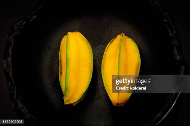 yellow starfruit on black background - sliced starfruit stock pictures, royalty-free photos & images