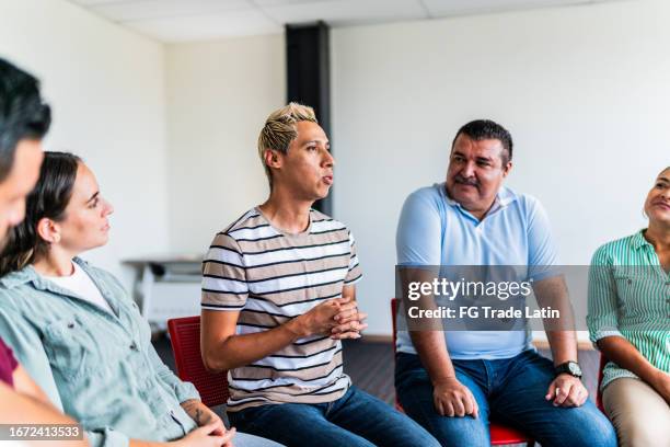 mid adult man introducing himself in group therapy at mental health center - weakness stock pictures, royalty-free photos & images