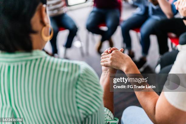 primer plano de personas tomadas de la mano en una terapia de grupo - esclavitud fotografías e imágenes de stock