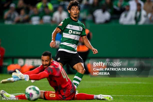 Sporting's Japanese midfielder Hidemasa Morita airs with Moreirense's Brazilian goalkeeper Kewin Silva during the Portuguese League football match...