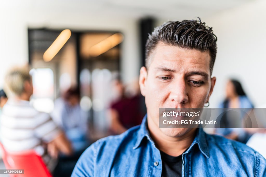 Worried mid adult man in a group therapy