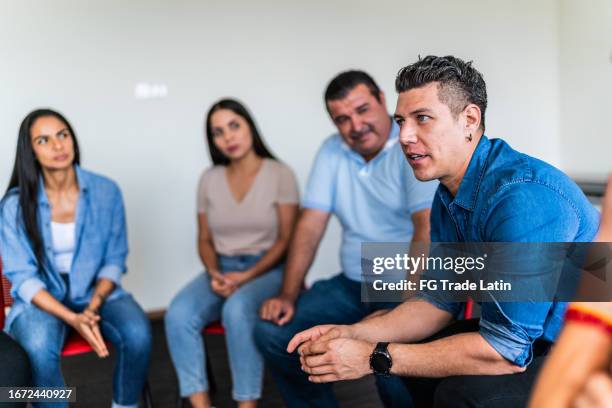 mid adult man talking in a group - support group leader stock pictures, royalty-free photos & images