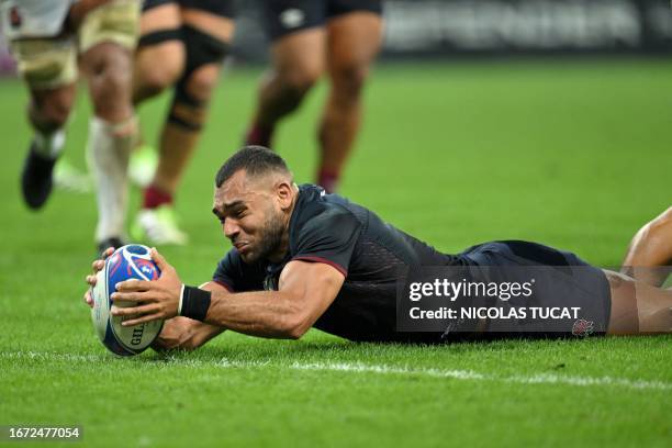 England's outside centre Joe Marchant dives across the line to score a try during the France 2023 Rugby World Cup Pool D match between England and...