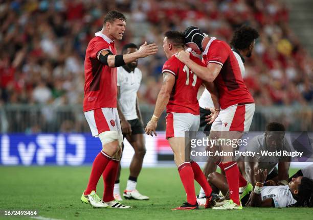 Josh Adams of Wales celebrates a big hit with Will Rowlands and Adam Beard of Wales during the Rugby World Cup France 2023 match between Wales and...
