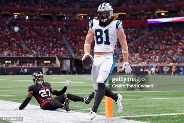 Hayden Hurst of the Carolina Panthers runs past Richie Grant of the Atlanta Falcons while scoring a touchdown during the second quarter at...