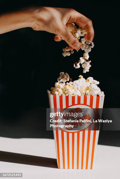 hand pouring pop corn - gravity film stock pictures, royalty-free photos & images