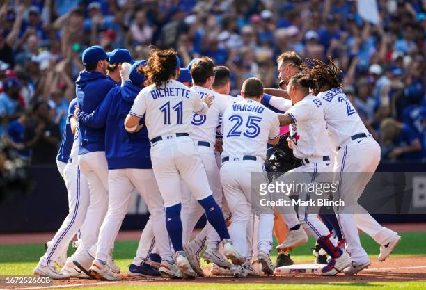 Matt Chapman of the Toronto Blue Jays is mobbed by teammates after hitting a walk off RBI double to defaet the Boston Red Sox during the ninth inning...