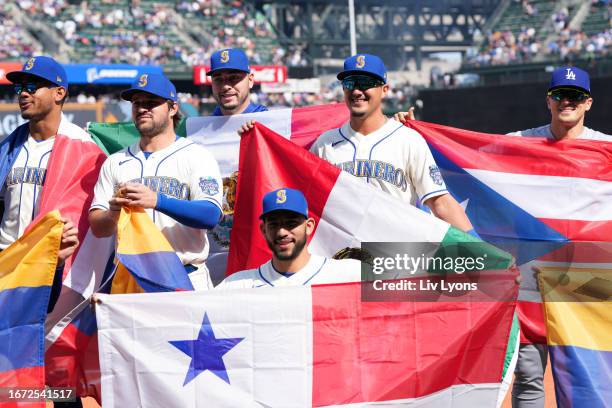 Members of the Seattle Mariners and the Los Angeles Dodgers hold flags corresponding to their heritage in honor of the Mariners' Hispanic Heritage...
