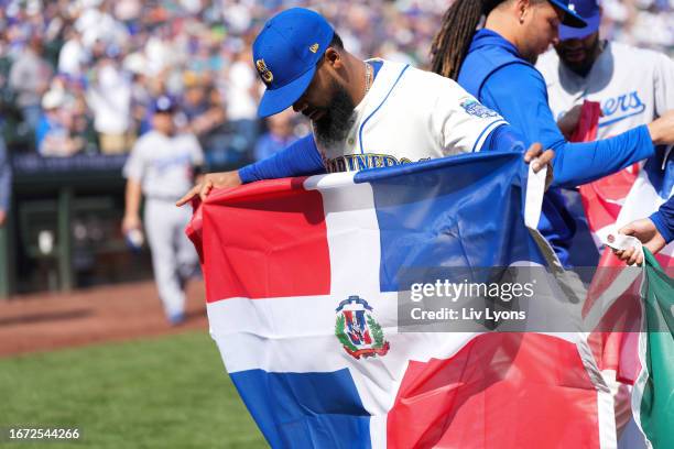 Teoscar Hernandez of the Seattle Mariners holds the flag of the Dominican Republic in honor of the Mariners' Hispanic Heritage Day game prior to the...