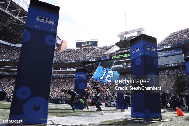 Jon Rhattigan of the Seattle Seahawks carries the 12 flag onto the field prior to the game against the Los Angeles Rams at Lumen Field on September...